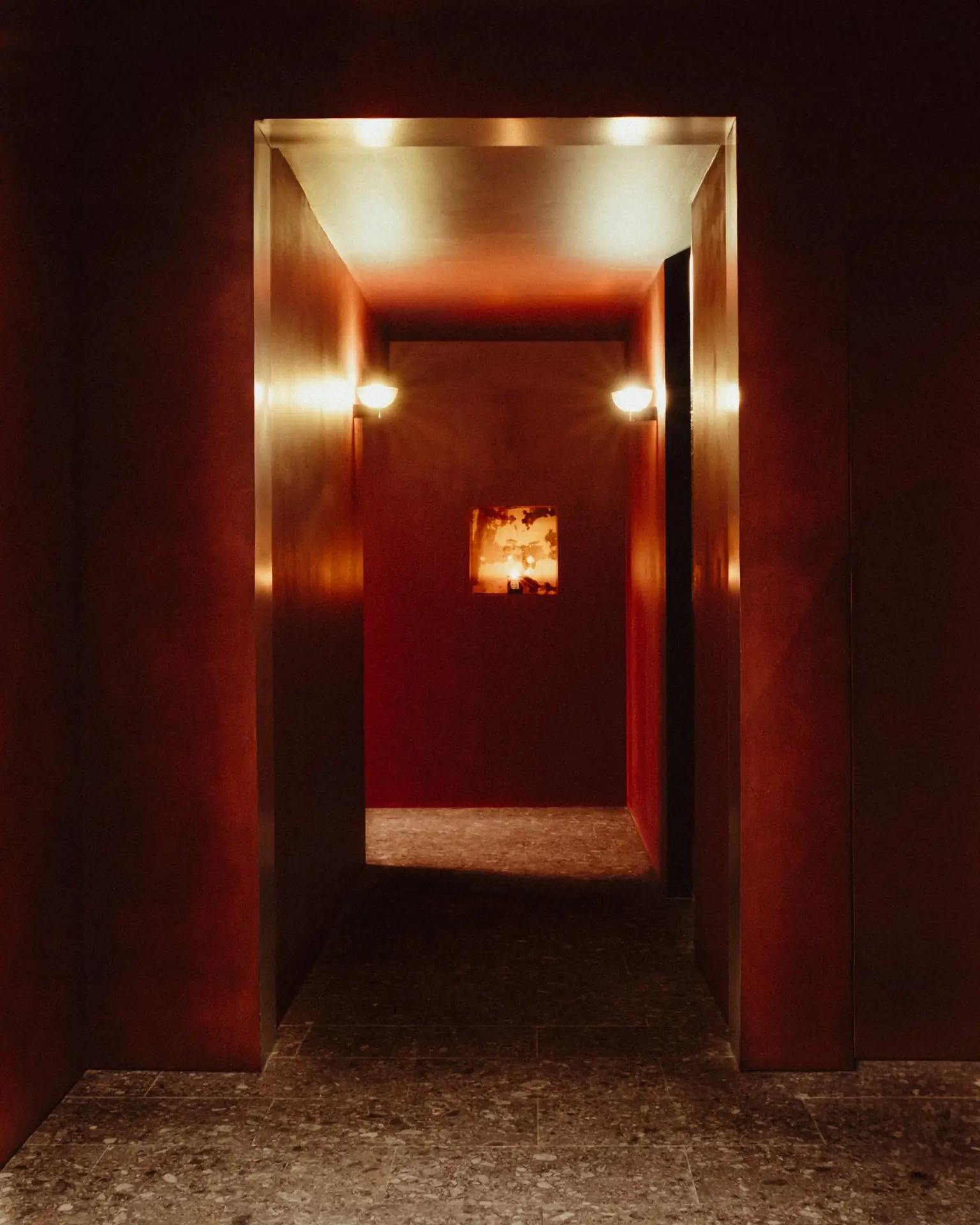 Couloir habillé de laiton, appliques lumineuses, oeuvre encadrée