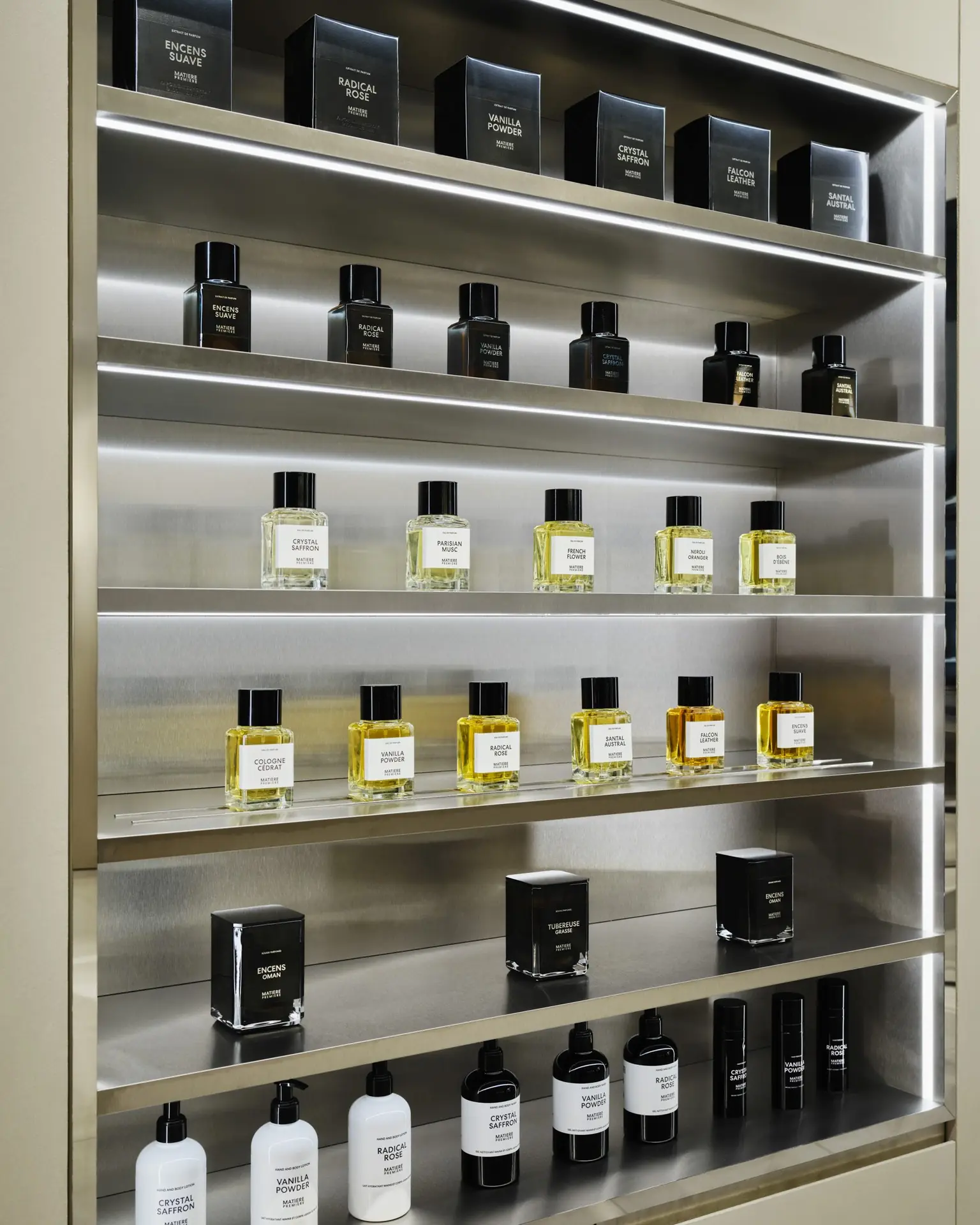 Étagères rétroéclairées en acier : extraits, eaux de parfum, bougies et soins