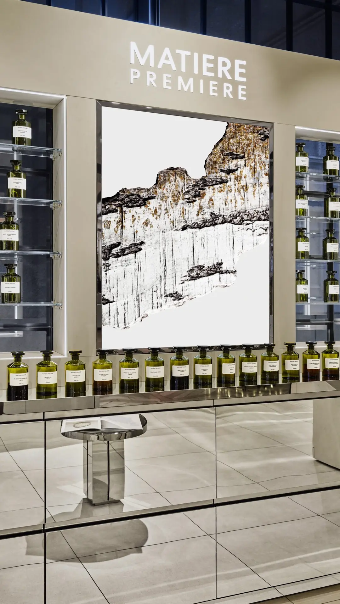 Mur Matiere Premiere, flacons de matières premières et visuel minéral, base miroir